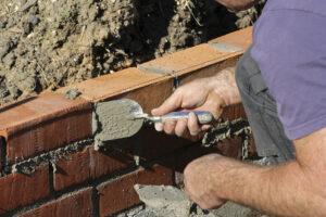 Mason laying brick at construction site